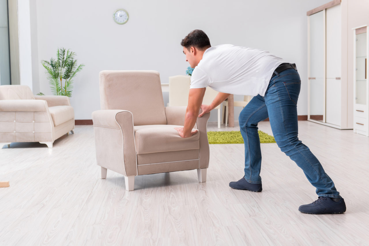 Man moving furniture at home